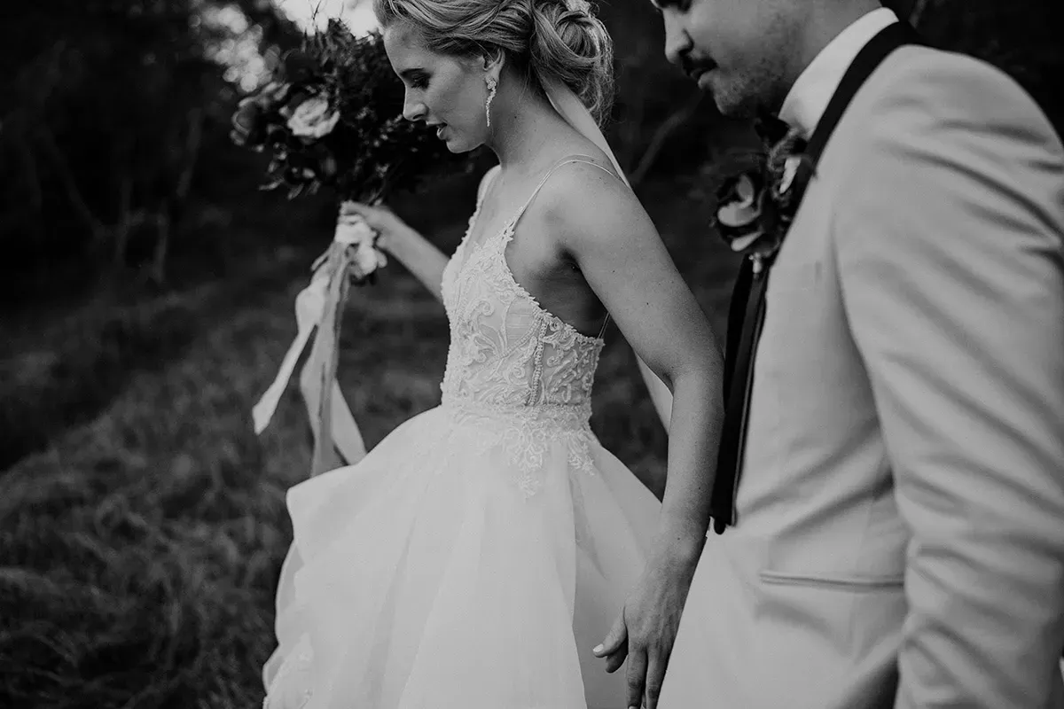 Natural bridal hair, soft undone updo on a bride walking with her groom, styled by Lisa Fowler