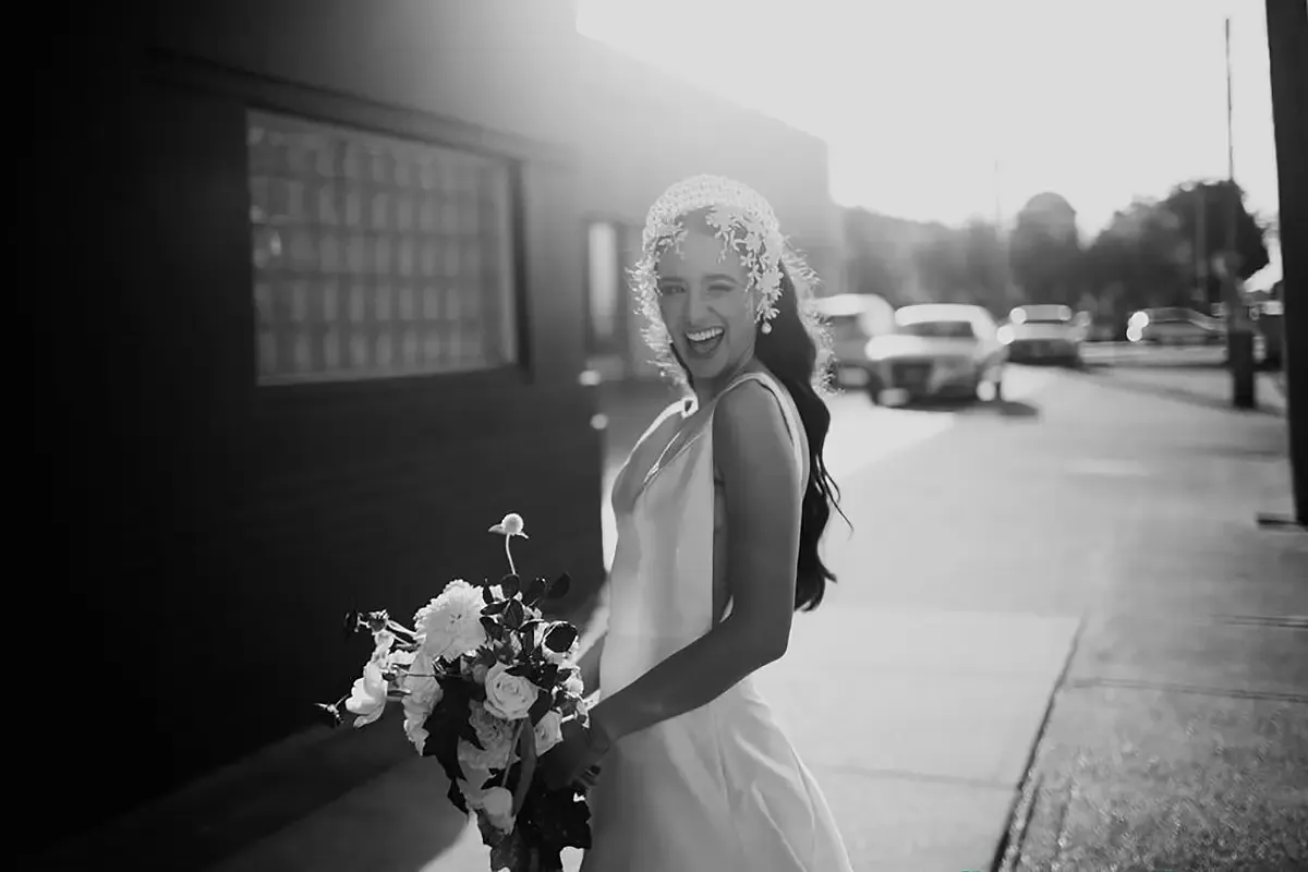 Bride laughing in natural light with a soft, traditional makeup finish